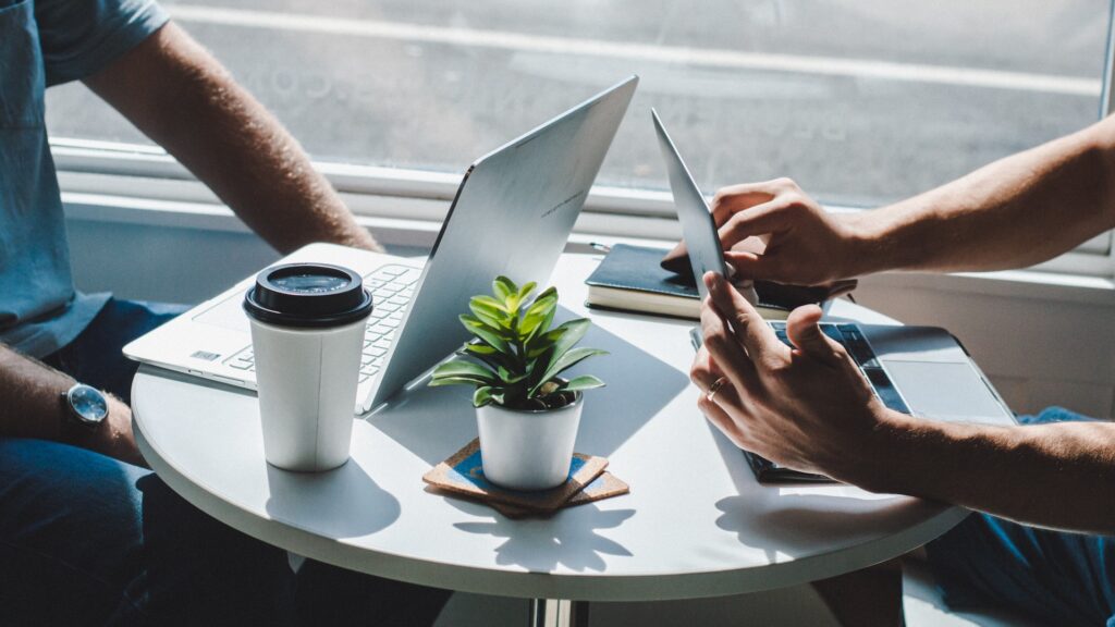 Interview scene with laptops on the table and plants and coffee